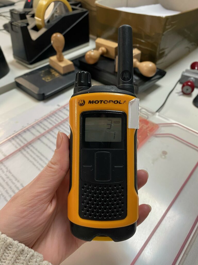 Holding an orange motorola radio